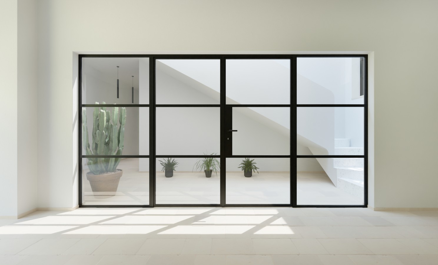 Minimalist room with a large black-framed glass door, revealing potted plants and a staircase in a bright, white space.